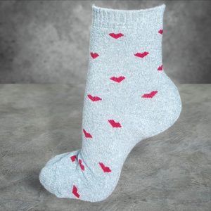 Light gray bamboo terry socks with red hearts, displayed on a textured gray background.